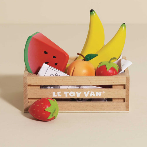 Wooden toy crate of fruits by Le Toy Van, including bananas, strawberries, a peach, and a watermelon slice for healthy eating role play.