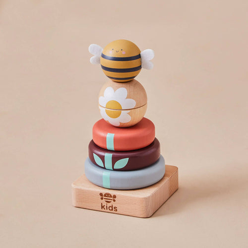 Wooden Bee Stacker Toy by Just Bee Kids with muted rainbow stacking rings and a friendly bee topper, designed for toddlers.