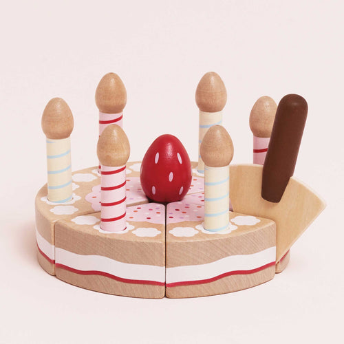 Wooden birthday cake toy by Le Toy Van with velcro slices, five removable candles, a strawberry topper, and a wooden serving slice.